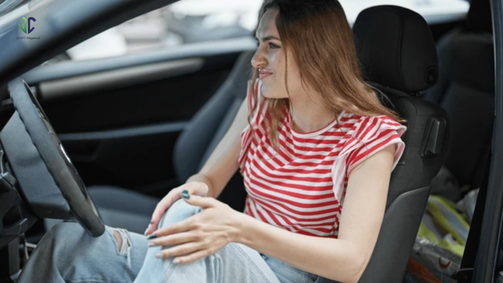 Person in car holding painful knee while seated